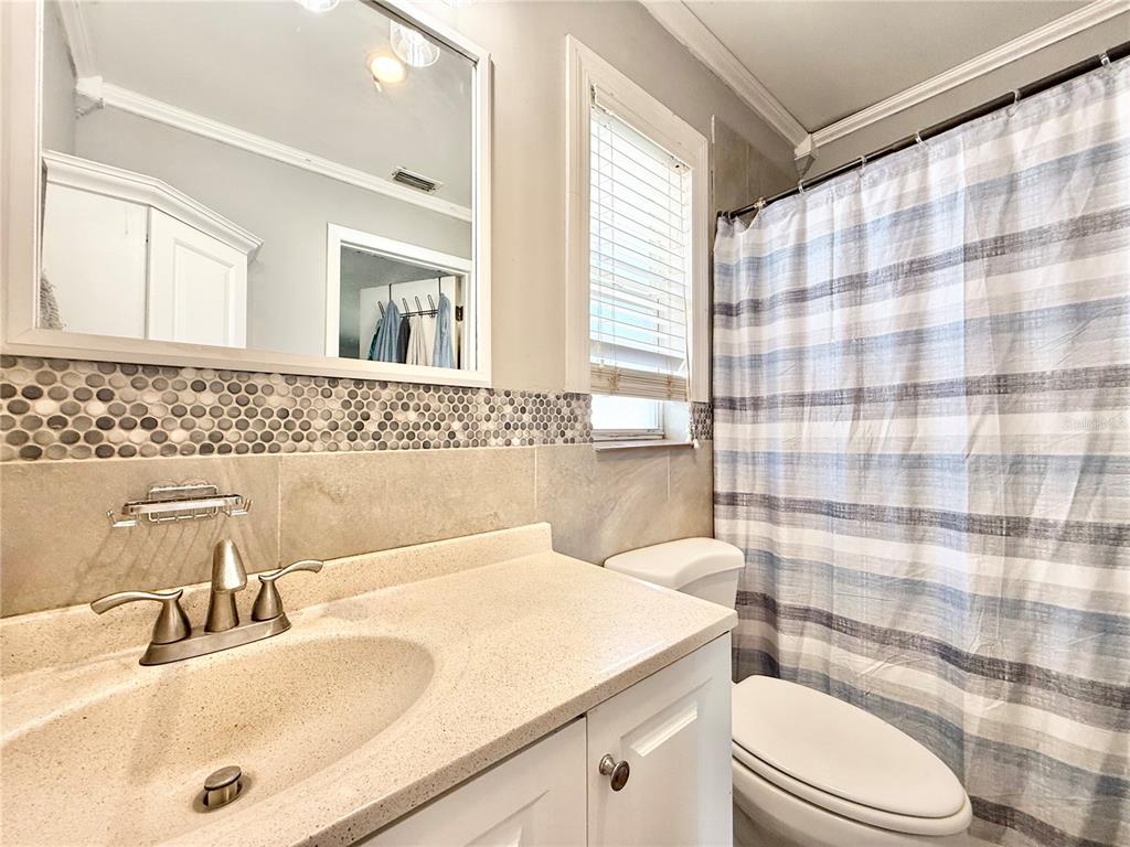 1784 Taylor Lake Place Largo, FL 33778 - Photo 15 of 24 a bathroom with a sink a toilet and shower curtain