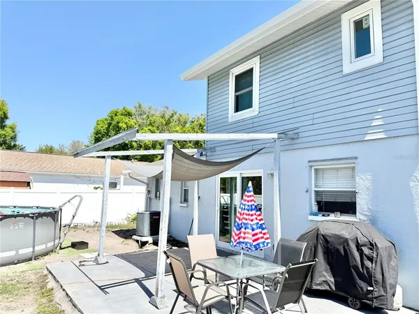 a view of a patio with a table and chairs under an umbrella