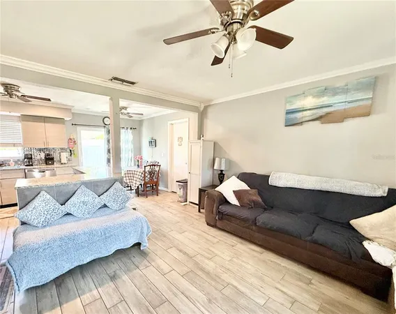 a living room with furniture and a view of kitchen