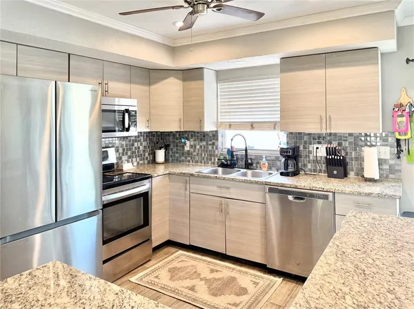 a kitchen with stainless steel appliances granite countertop a stove a sink and a refrigerator