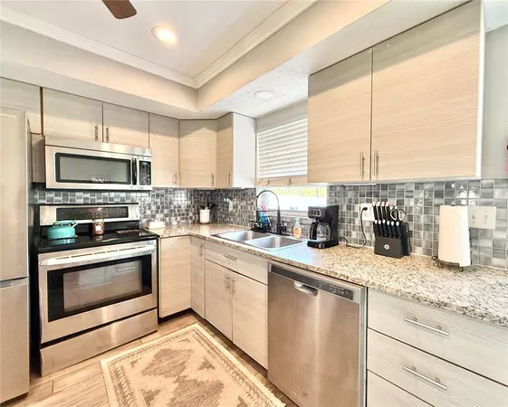 a kitchen with sink a microwave and cabinets