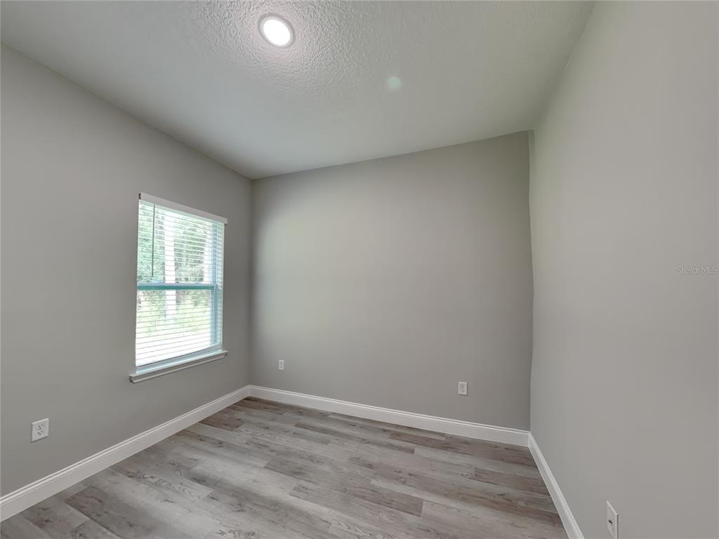 11604 North Kenlake Circle Citrus Springs, FL 34434 - Photo 13 of 15 an empty room with wooden floor and windows