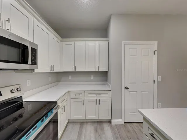 a kitchen with white cabinets and sink