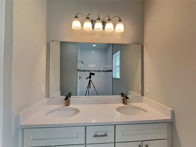 a bathroom with double vanity sinks and a mirror