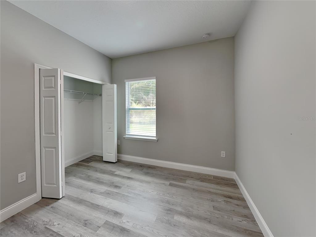 11604 North Kenlake Circle Citrus Springs, FL 34434 - Photo 10 of 15 an empty room with wooden floor and windows