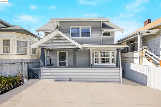 a view of a house with a small yard and wooden fence