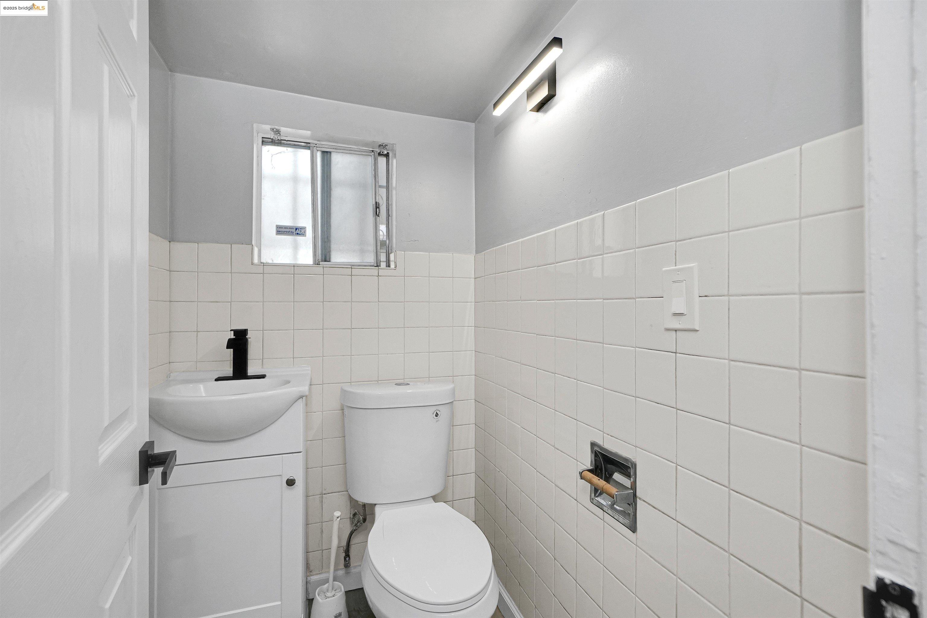 2207 East 19th Street Oakland, CA 94606 - Photo 24 of 30 a bathroom with a toilet sink and mirror