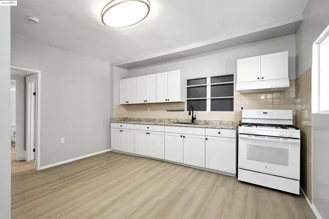a kitchen with granite countertop white cabinets and white appliances