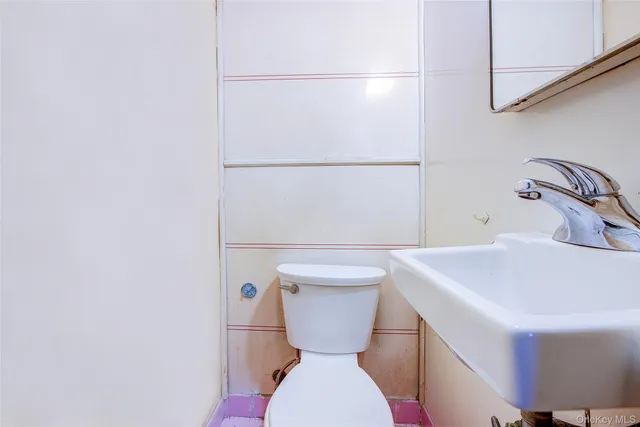 a bathroom with a sink a toilet and a mirror