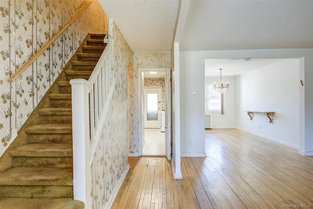 a view of a hallway with wooden floor and staircase