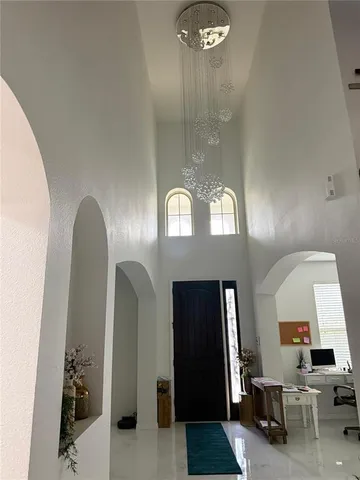 a view of a hallway with entryway dining room and chandelier