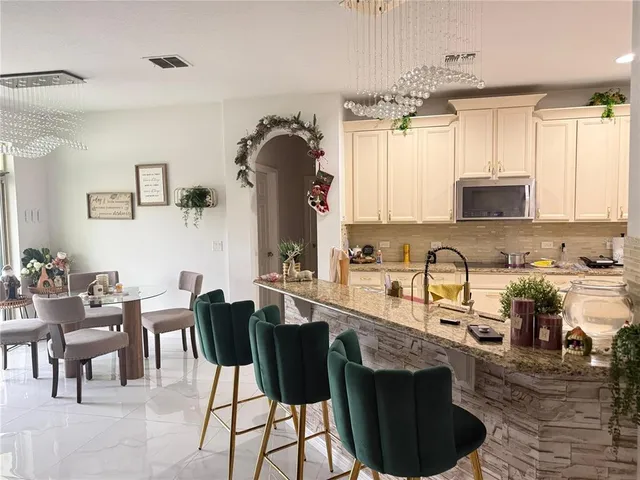 a kitchen with cabinets and chairs in it