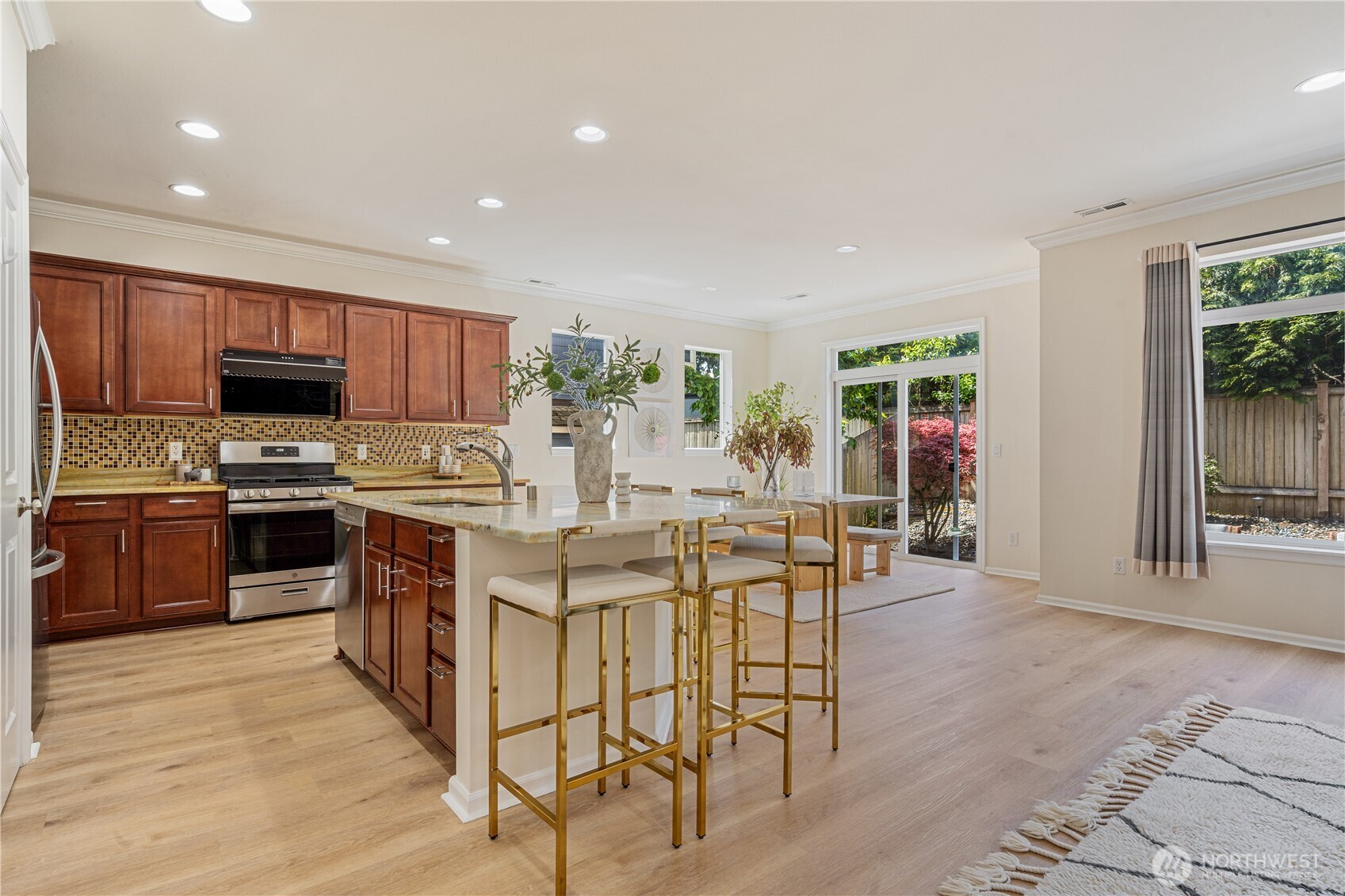9528 25th Drive Southeast Everett, WA 98208 - Photo 12 of 36 a kitchen with stainless steel appliances kitchen island granite countertop a stove top oven a sink dishwasher a dining table and chairs with wooden floor