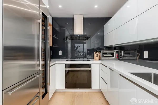 a large kitchen with stainless steel appliances granite countertop a large stove top oven and cabinets