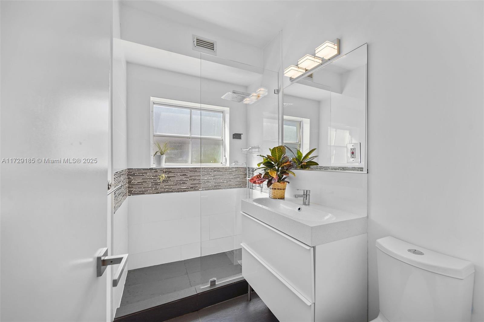 832 15th Street, Unit 4 Miami Beach, FL 33139 - Photo 12 of 17 a bathroom with a sink a vanity and a mirror