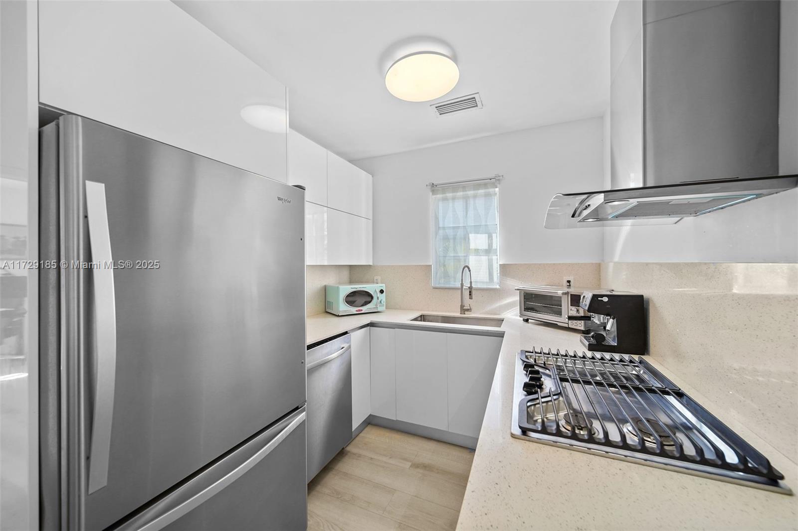 832 15th Street, Unit 4 Miami Beach, FL 33139 - Photo 6 of 17 a kitchen with a refrigerator and a stove top oven