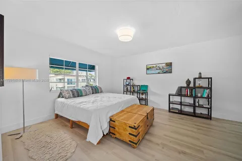 a bedroom with a bed a table and painting on the wall