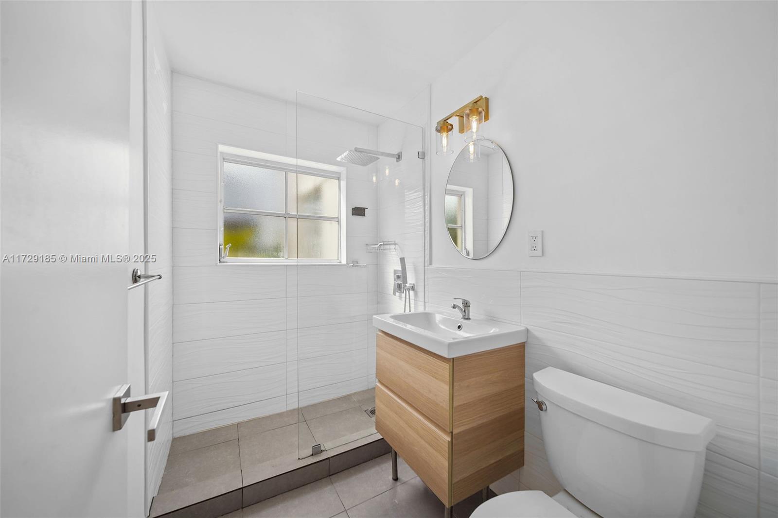 832 15th Street, Unit 4 Miami Beach, FL 33139 - Photo 10 of 17 a bathroom with a toilet a sink and mirror