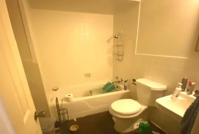 a bathroom with a toilet sink and mirror