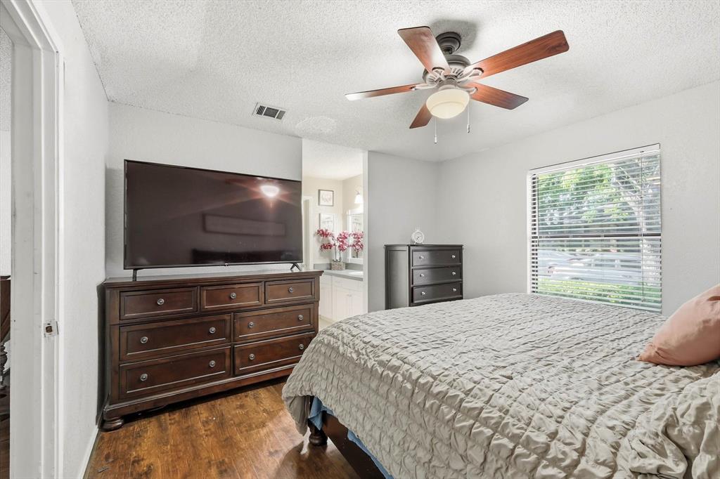 1312 Hackamore Street Mesquite, TX 75149 - Photo 12 of 23 Bedroom with dark wood finished floors, a textured ceiling, ceiling fan, and ensuite bath