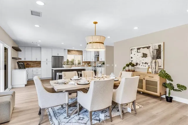 a dining room with furniture a chandelier and wooden floor