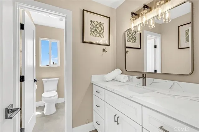 a bathroom with a granite countertop toilet sink and mirror