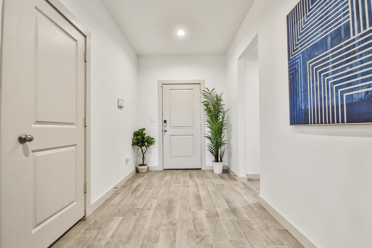 6802 55th Street Lubbock, TX 79407 - Photo 21 of 36 a view of a room with wooden floor and a potted plant