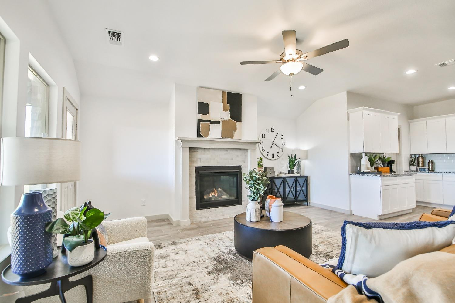 6802 55th Street Lubbock, TX 79407 - Photo 23 of 36 a living room with furniture a fireplace and a ceiling fan