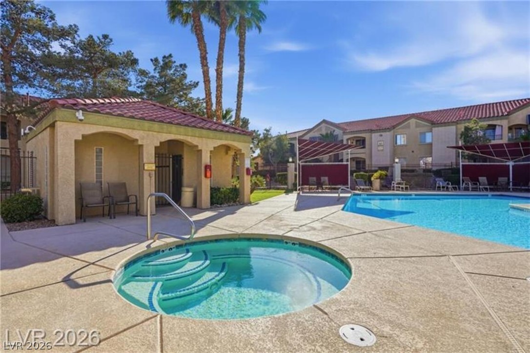 7885 West Flamingo Road, Unit 2171 Las Vegas, NV 89147 - Photo 3 of 22 Lush landscaping surrounds a sparkling community pool and spa, ideal for relaxation and recreation.