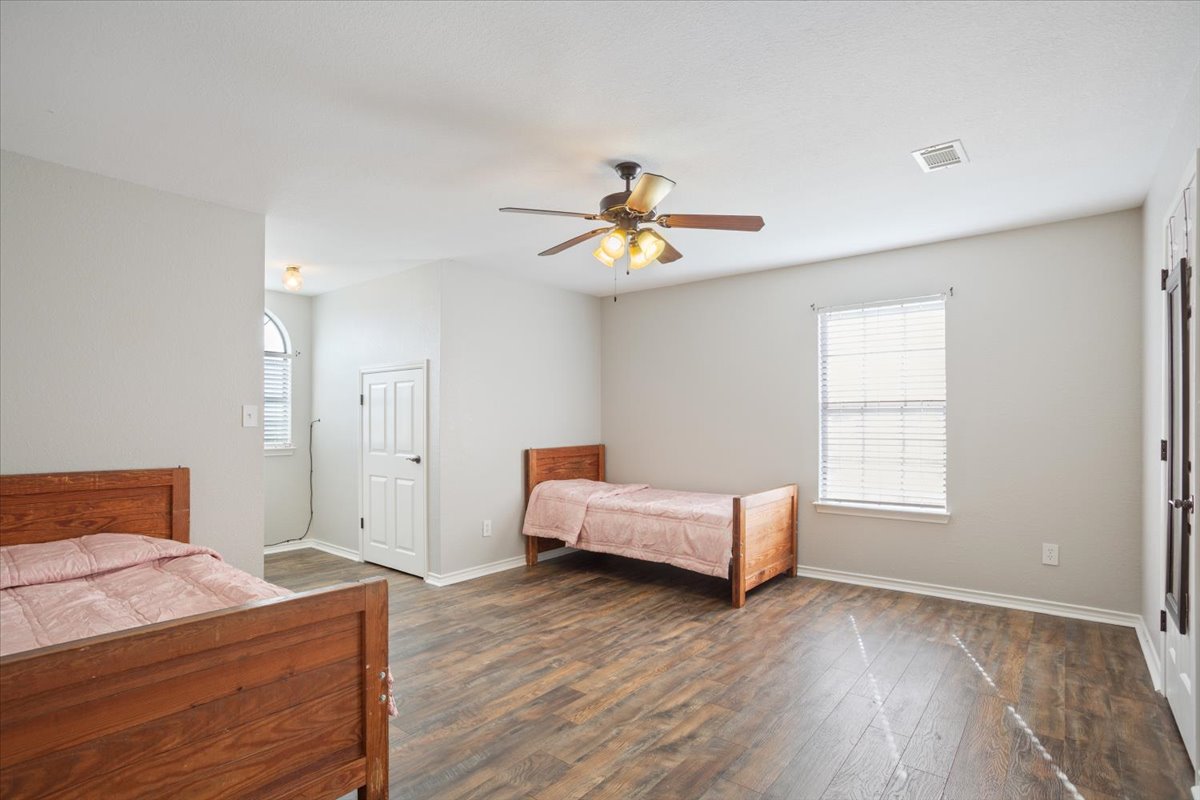 8600 Five Wells Road Rogers, TX 76569 - Photo 24 of 40 Bedroom with hardwood / wood-style flooring, a ceiling fan, and multiple windows