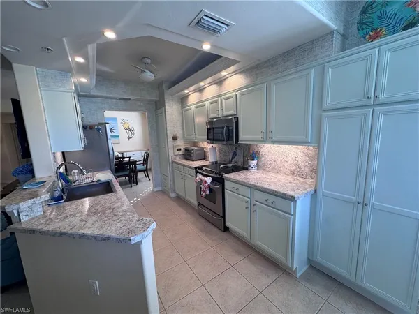 a kitchen with granite countertop sink stove and cabinets