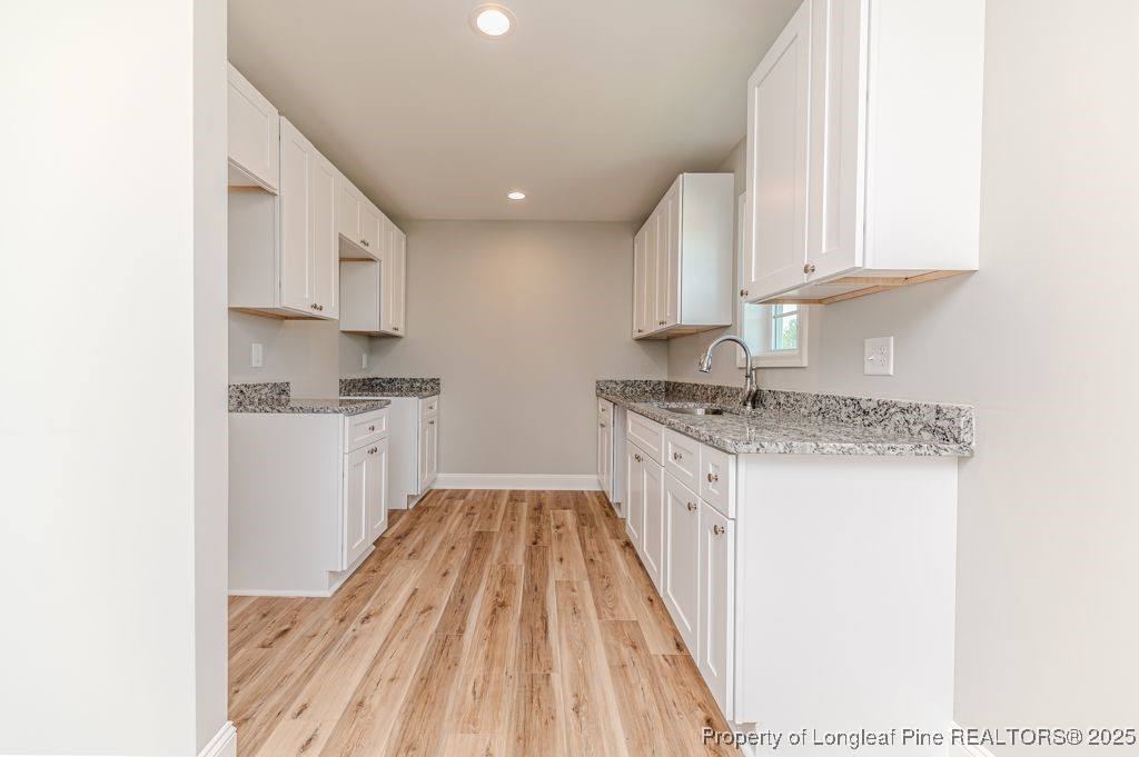 932 Allstar Avenue Cameron, NC 28326 - Photo 12 of 33 a kitchen with granite countertop white cabinets sink and stainless steel appliances