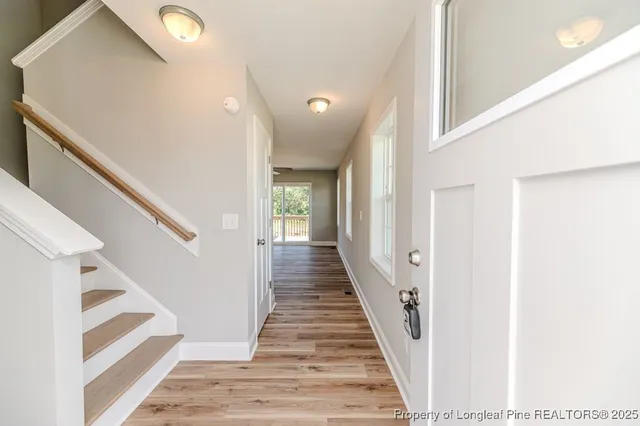 a view of a hallway with wooden floor and staircase