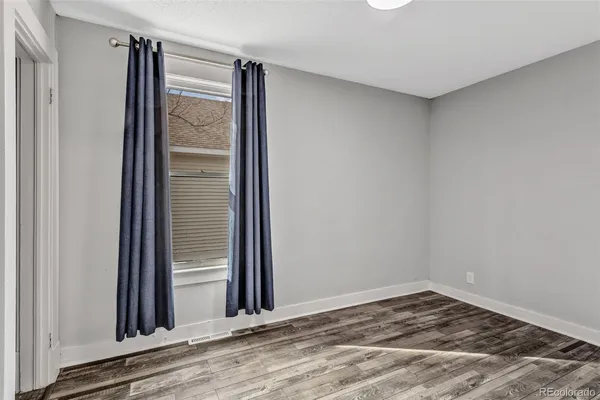 a view of a room with wooden floor and a window