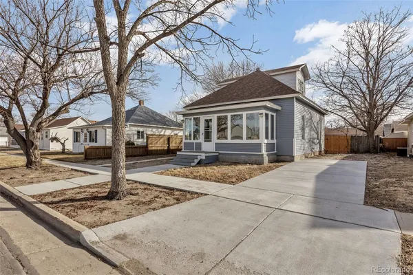 a front view of a house with a yard covered in snow