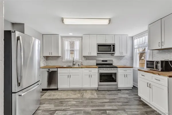 a kitchen with white cabinets stainless steel appliances and a counter space