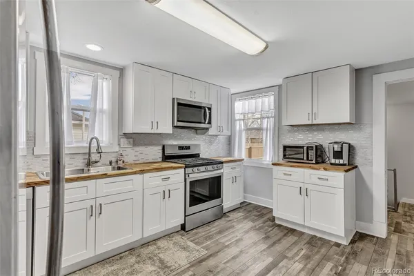 a kitchen with cabinets stainless steel appliances a sink and a window