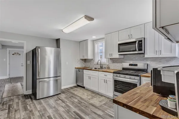 a kitchen with granite countertop a refrigerator stove and microwave