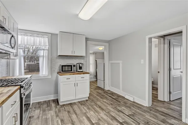 a kitchen with granite countertop a stove a sink and a refrigerator