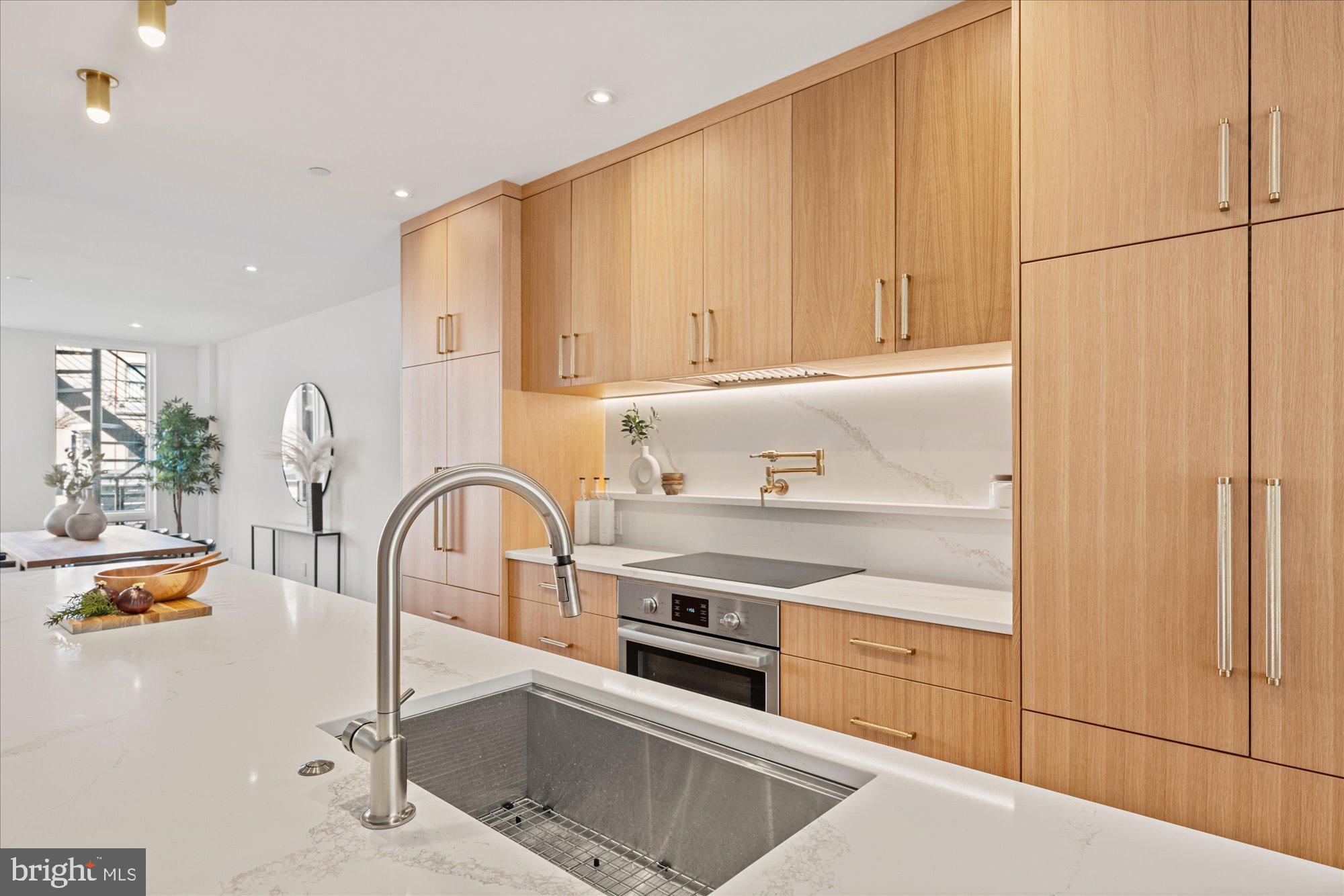 1319 R Street Northwest, Unit 2100 Washington, DC 20009 - Photo 11 of 36 a kitchen with stainless steel appliances granite countertop a sink a stove and a refrigerator
