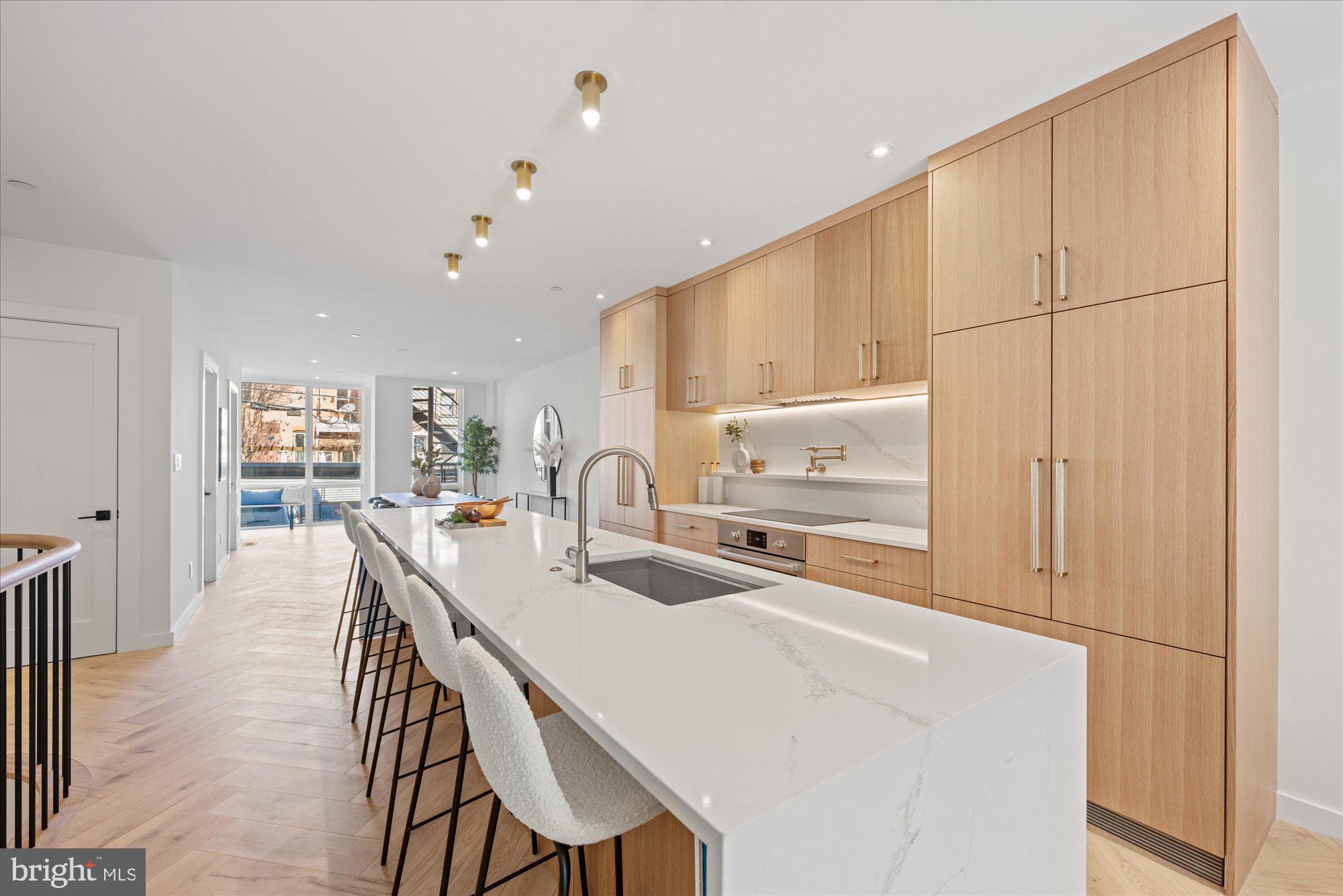 1319 R Street Northwest, Unit 2100 Washington, DC 20009 - Photo 8 of 36 a kitchen with kitchen island a stove a table and chairs in it