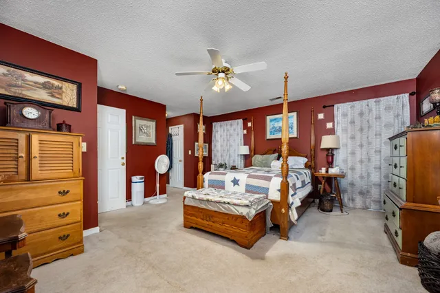 a spacious bedroom with a bed a couch and dresser