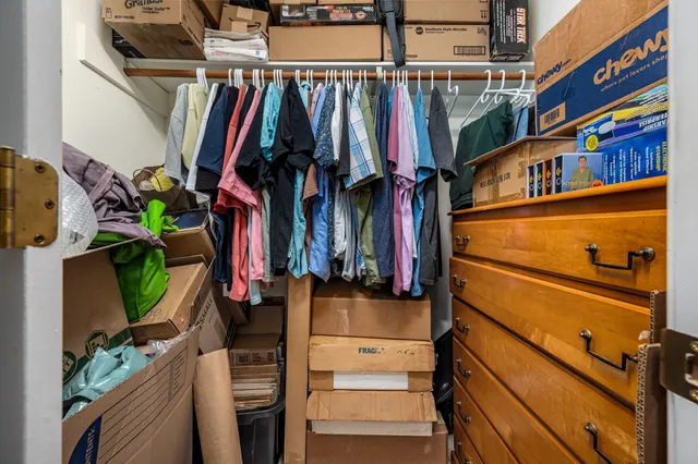a view of walk in closet with clothes