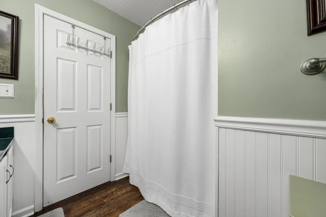 a bathroom with a granite countertop sink a large mirror and a toilet