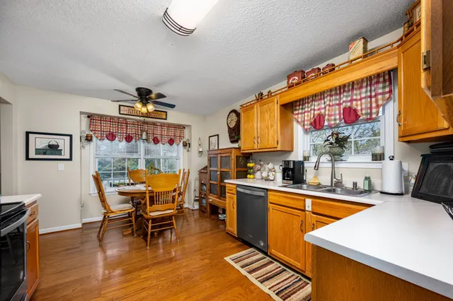 a kitchen with stainless steel appliances a stove a kitchen island next to a window