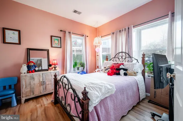 a bedroom with a bed and large windows