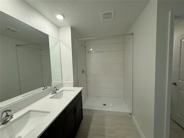 a bathroom with a double vanity sink mirror and shower