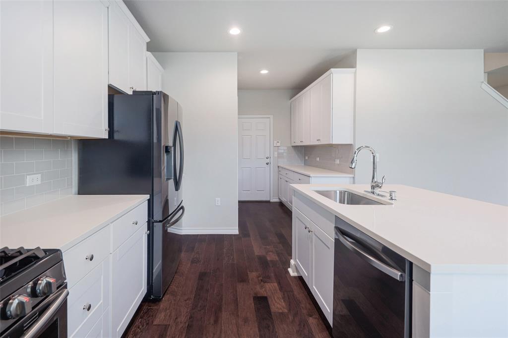2004 Rinker Ranch Drive Austin, TX 78725 - Photo 5 of 23 a kitchen with a sink a refrigerator and a stove top oven