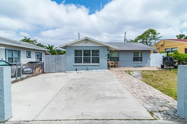 a front view of a house with a yard and potted plants
