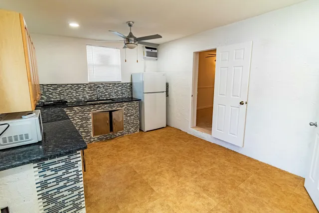 a bathroom with a granite countertop sink a toilet and shower